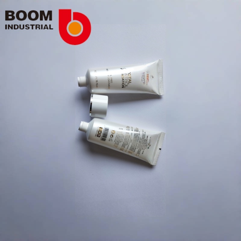 White pearlescent tube, 30 mm diameter, with gold foil stamping and silver foil stamping on the twist cap.